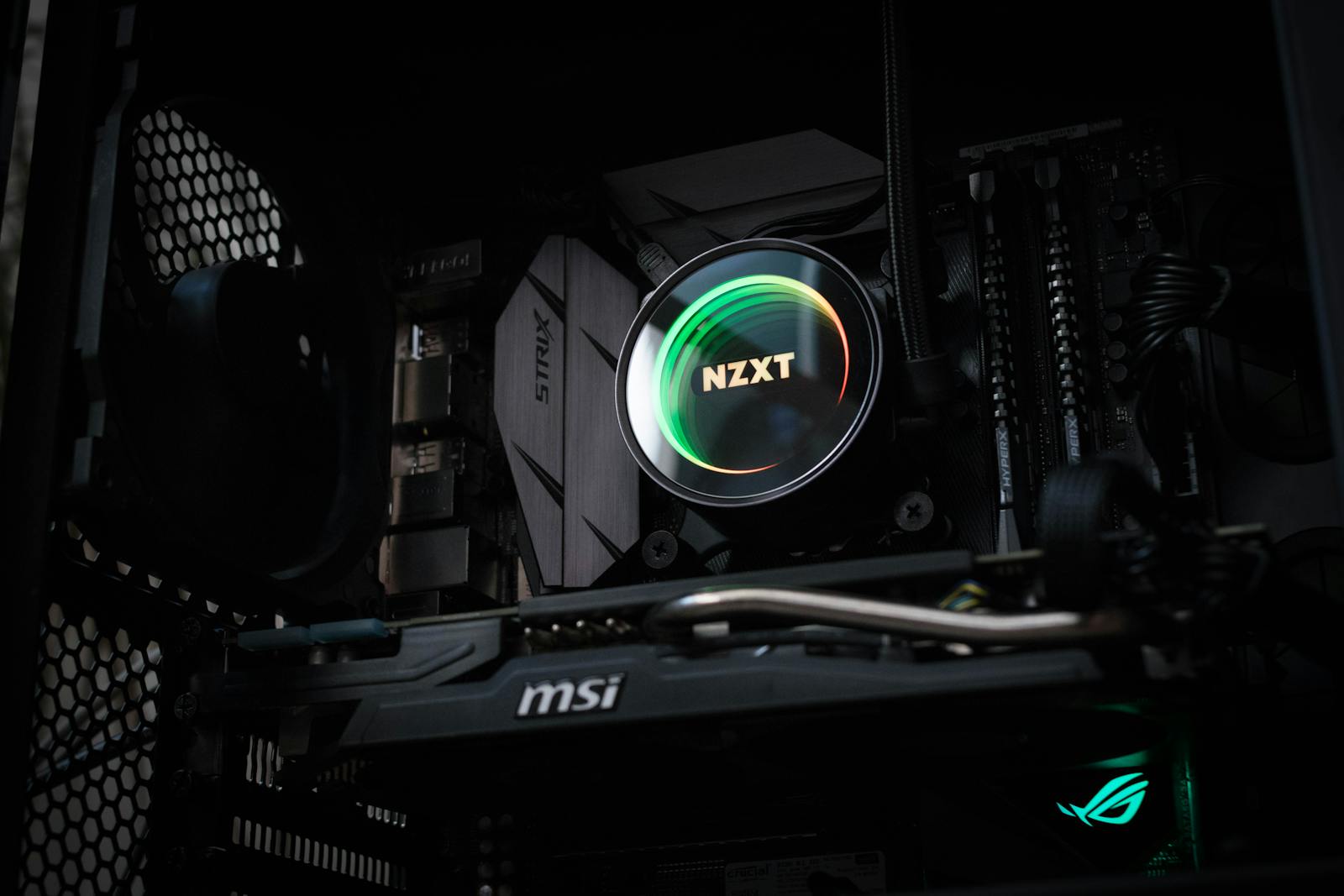 Detailed view of an illuminated NZXT cooler inside a gaming PC showcasing advanced components.