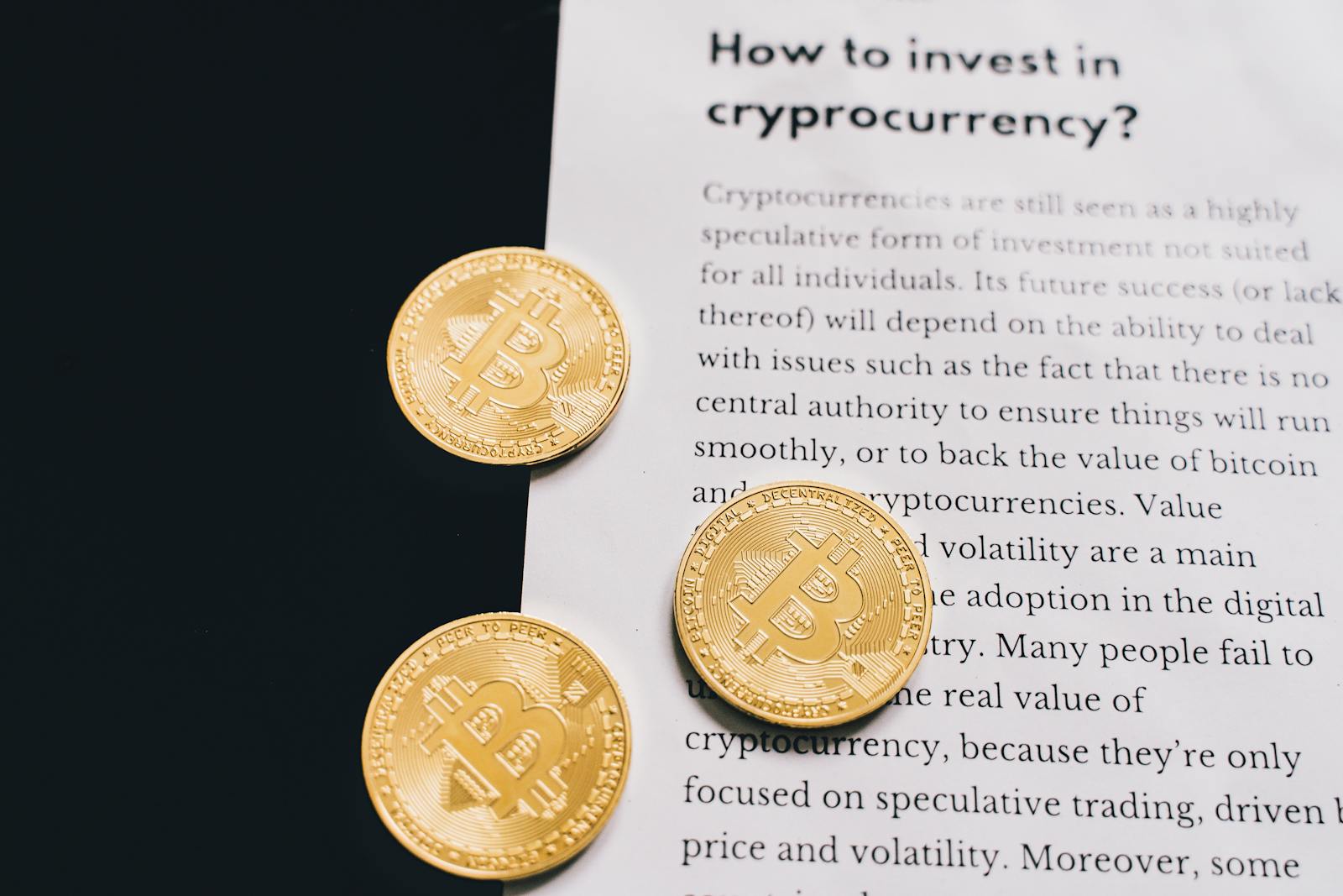 Gold Bitcoin coins on top of a cryptocurrency investment guide. High-quality finance and cryptocurrency image.