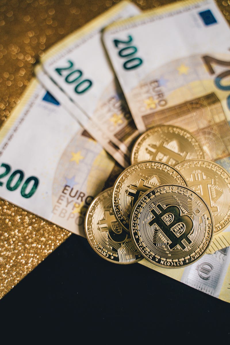 Close-up of Euro banknotes with Bitcoin coins on a glittery background symbolizing modern currency and investment.